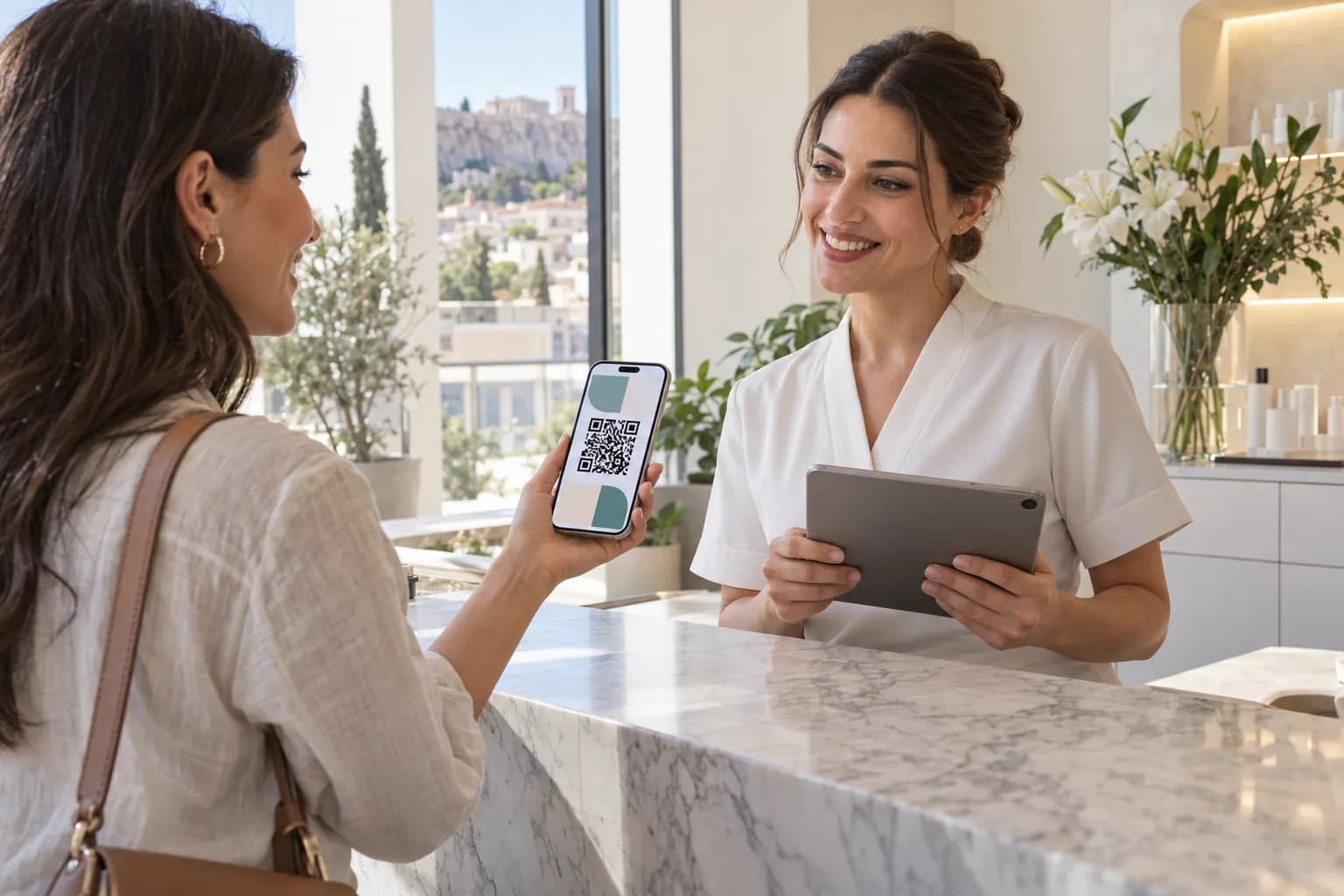 Ρεσεψιονίστ κέντρου αισθητικής με tablet και πελάτισσα που δείχνει την κάρτα loyalty στο κινητό της